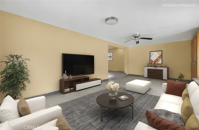 living area with a ceiling fan and baseboards