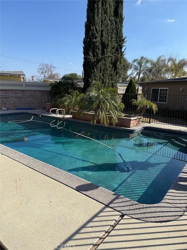 view of swimming pool featuring fence and a fenced in pool