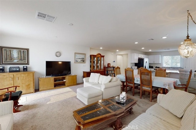 living area with recessed lighting, visible vents, and light colored carpet