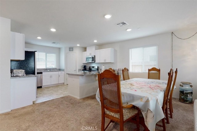 dining area with light colored carpet, visible vents, and recessed lighting