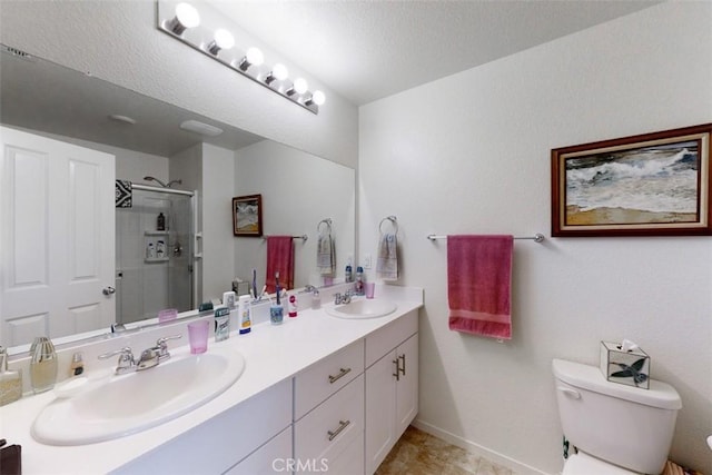 full bath with a sink, toilet, a shower stall, and double vanity