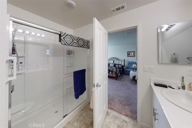 bathroom featuring vanity, visible vents, a stall shower, and ensuite bathroom