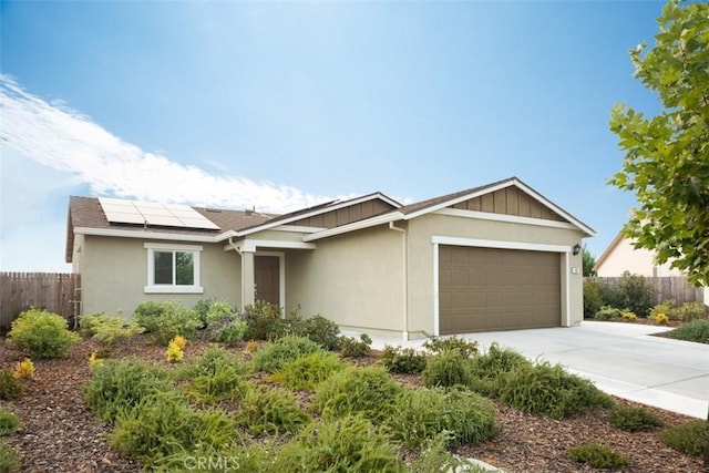 ranch-style home featuring stucco siding, driveway, a garage, fence, and roof mounted solar panels
