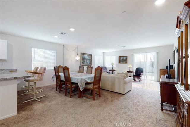dining space featuring light carpet, visible vents, and recessed lighting