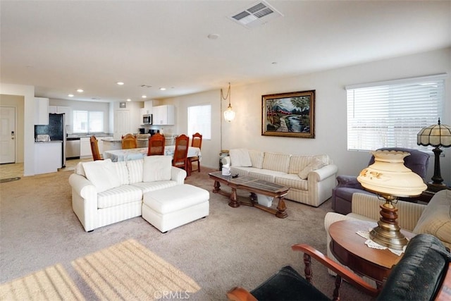 living room featuring light carpet, recessed lighting, visible vents, and a wealth of natural light