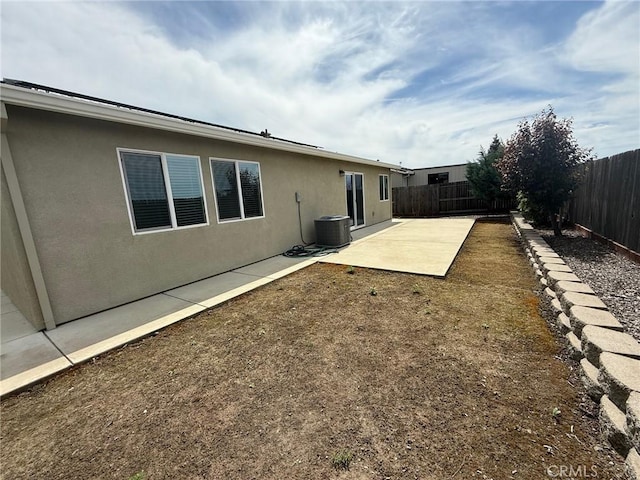 back of property with cooling unit, a patio area, a fenced backyard, and stucco siding