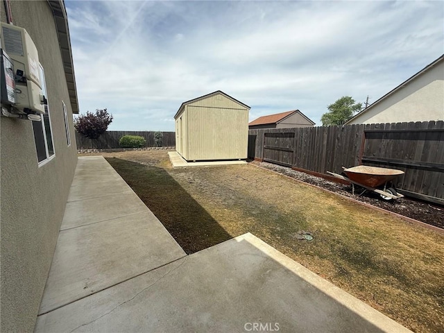 view of yard featuring a patio area, a fenced backyard, an outdoor structure, and a storage unit