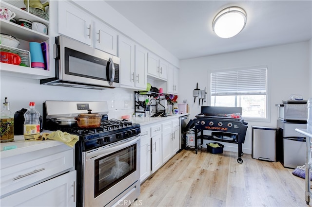 kitchen with white cabinetry, light hardwood / wood-style flooring, and appliances with stainless steel finishes