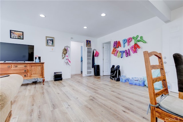 bedroom featuring beamed ceiling and light wood-type flooring