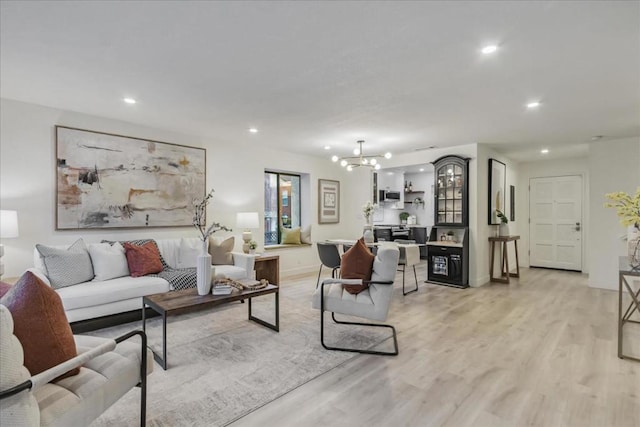 living room featuring a chandelier and light wood-type flooring