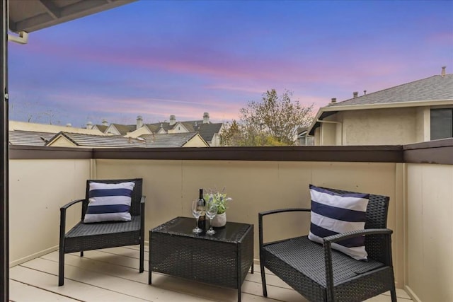 patio terrace at dusk featuring a balcony