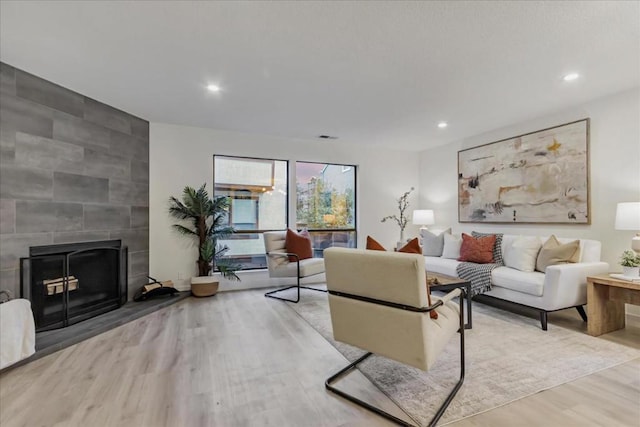 living room with a large fireplace and light wood-type flooring