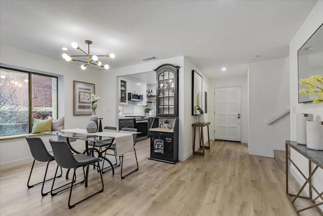 dining space featuring an inviting chandelier and light wood-type flooring