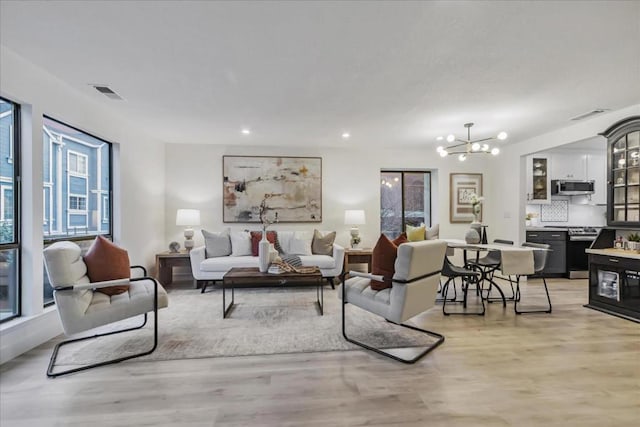 living room featuring an inviting chandelier and light hardwood / wood-style floors