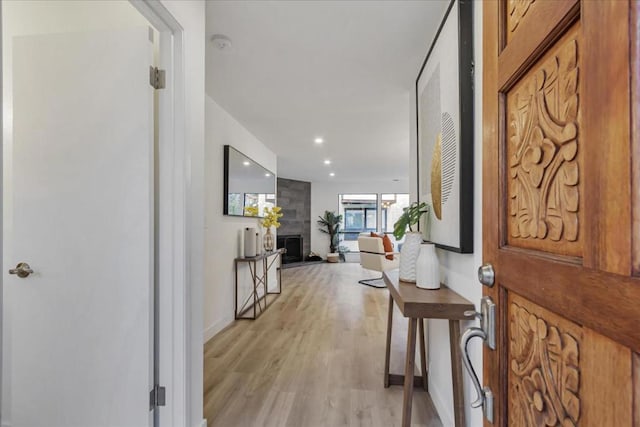 entrance foyer featuring a large fireplace and light hardwood / wood-style floors