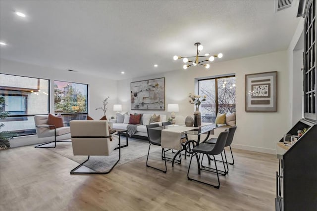 living room with an inviting chandelier and light wood-type flooring