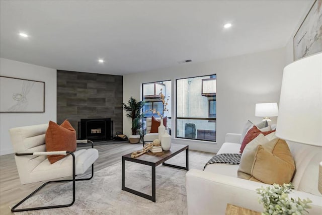 living room featuring a large fireplace and light hardwood / wood-style floors