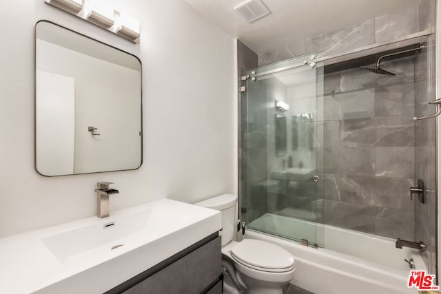 full bathroom with toilet, vanity, and bath / shower combo with glass door