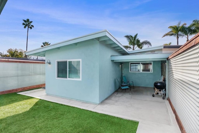 view of home's exterior with a yard and a patio