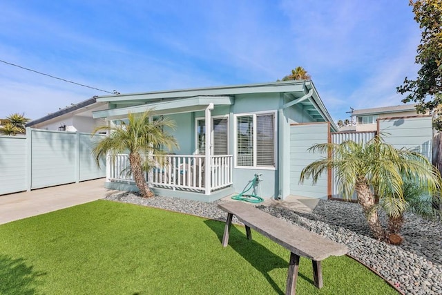 back of property featuring a porch and a yard