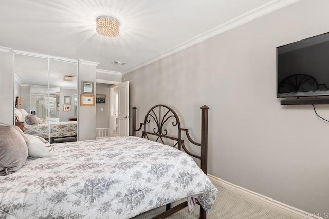 carpeted bedroom featuring ornamental molding and a closet