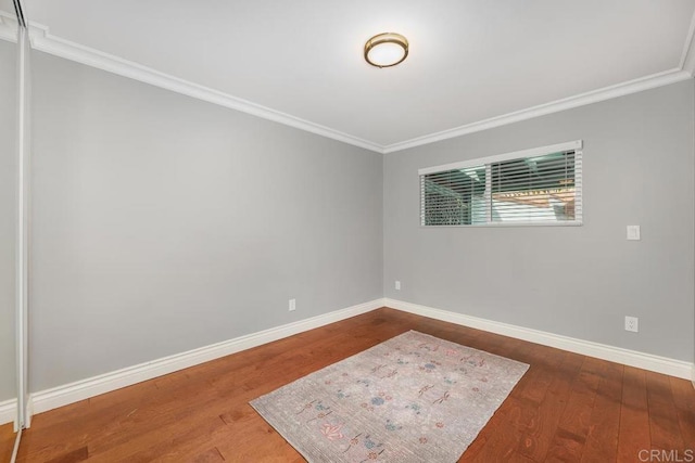 unfurnished room featuring crown molding and hardwood / wood-style floors