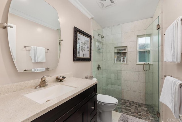 bathroom with crown molding, vanity, toilet, and a shower with shower door