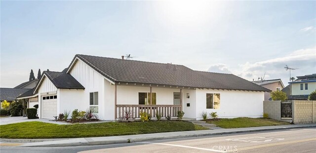 modern farmhouse style home featuring a garage, covered porch, and a front lawn