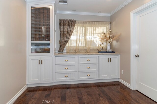 bar with ornamental molding, dark hardwood / wood-style flooring, light stone countertops, and white cabinets