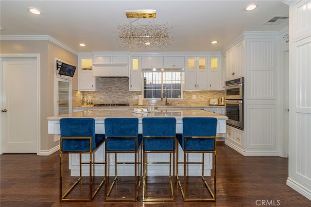 kitchen featuring double oven, a kitchen island, and white cabinets