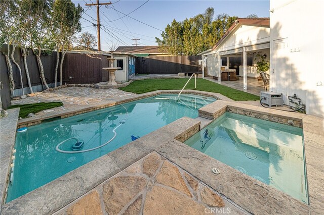 view of pool with an in ground hot tub and a patio area