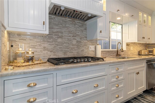 kitchen featuring sink, white cabinets, light stone counters, stainless steel appliances, and custom range hood