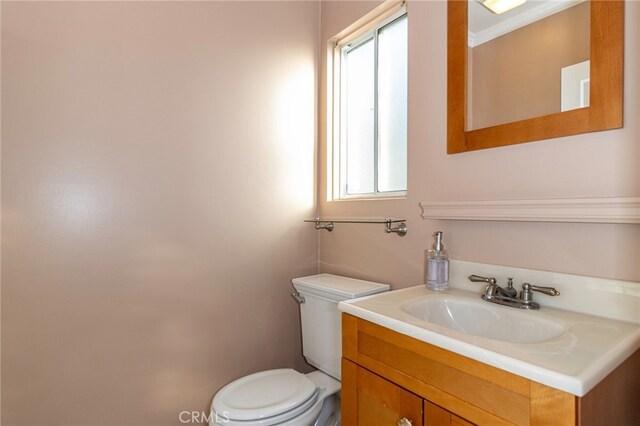 bathroom featuring vanity, a wealth of natural light, and toilet