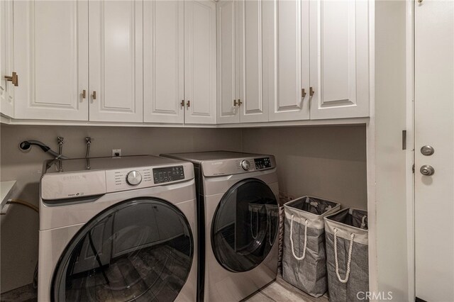 washroom with separate washer and dryer and cabinets