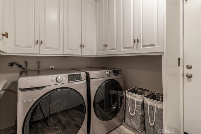 washroom featuring washing machine and clothes dryer and cabinet space