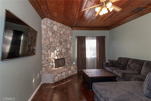 living room with dark wood-type flooring, a stone fireplace, wooden ceiling, ornamental molding, and ceiling fan