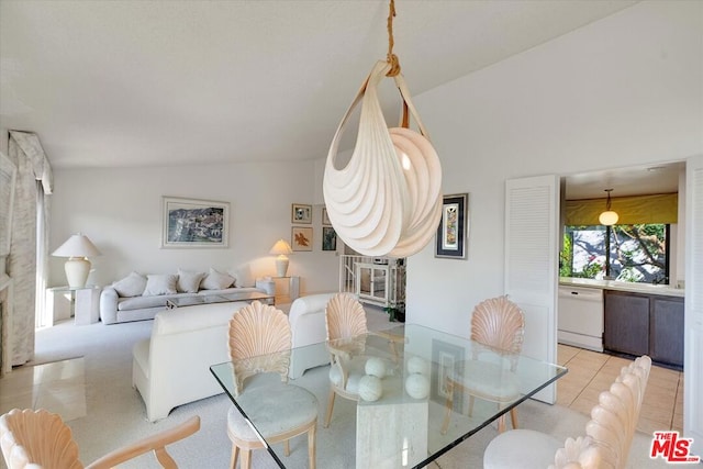 tiled dining space featuring vaulted ceiling