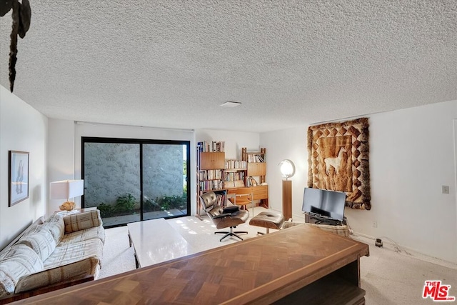 carpeted home office featuring a textured ceiling