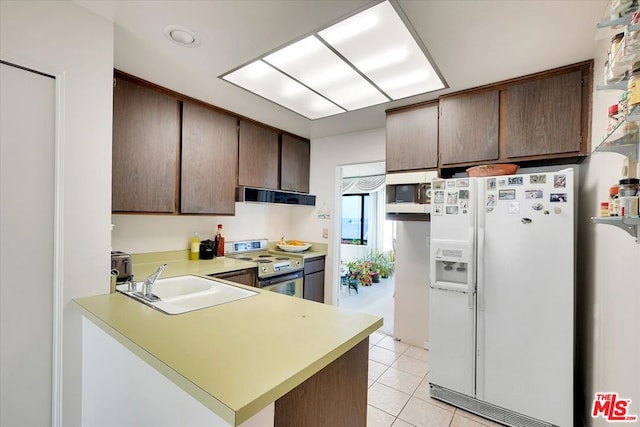 kitchen with extractor fan, sink, light tile patterned floors, kitchen peninsula, and white appliances