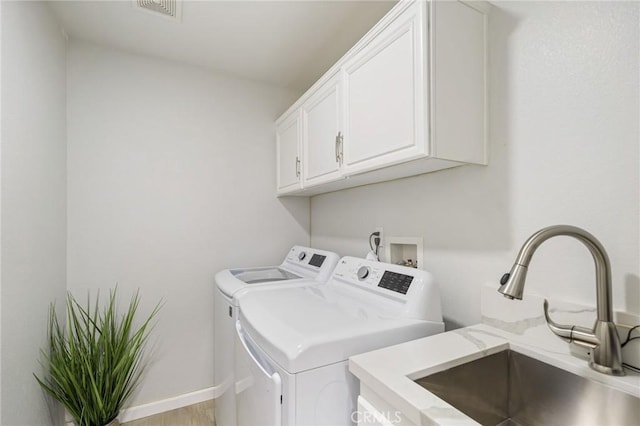 laundry room with cabinets, separate washer and dryer, sink, and light wood-type flooring