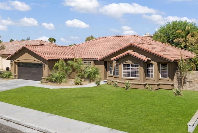 mediterranean / spanish home with a garage and a front yard