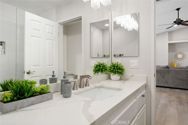 bathroom featuring vanity, wood-type flooring, and ceiling fan with notable chandelier