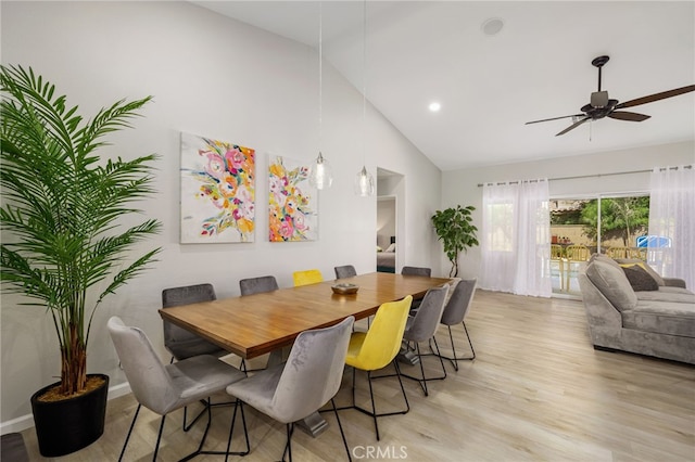 dining area with ceiling fan, high vaulted ceiling, and light wood-type flooring