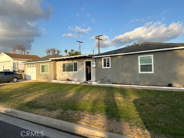 single story home featuring a garage and a front lawn