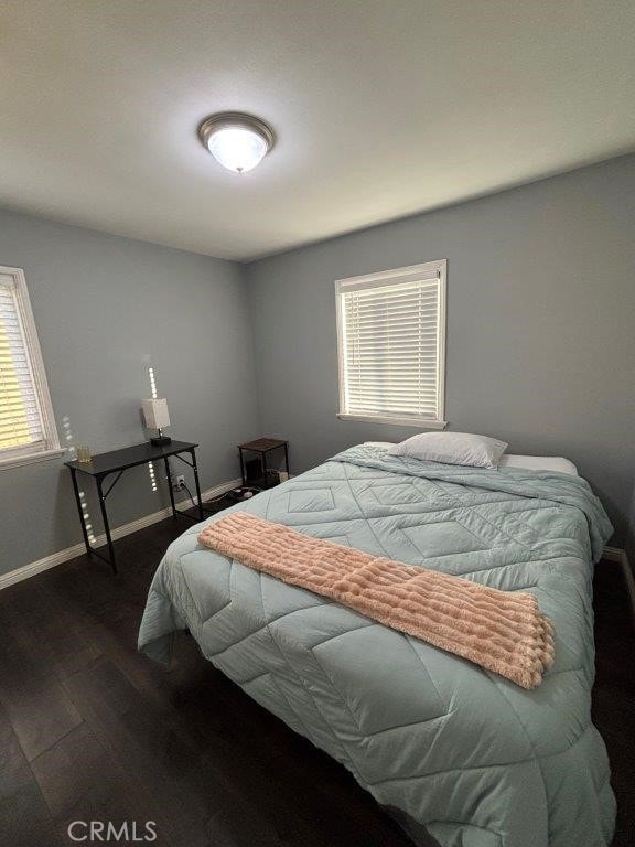 bedroom with dark hardwood / wood-style floors