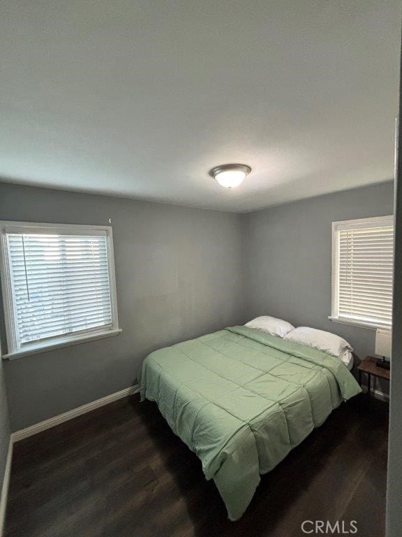 bedroom with dark hardwood / wood-style floors