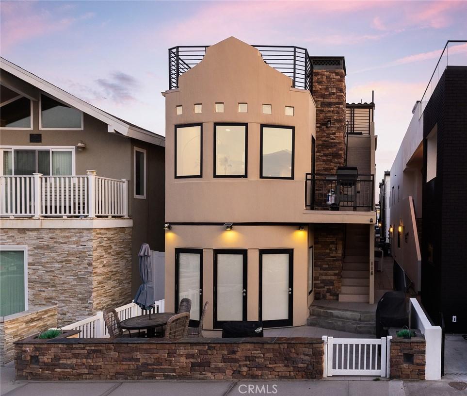 back house at dusk featuring a balcony