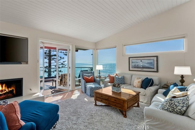 living room featuring vaulted ceiling and a water view