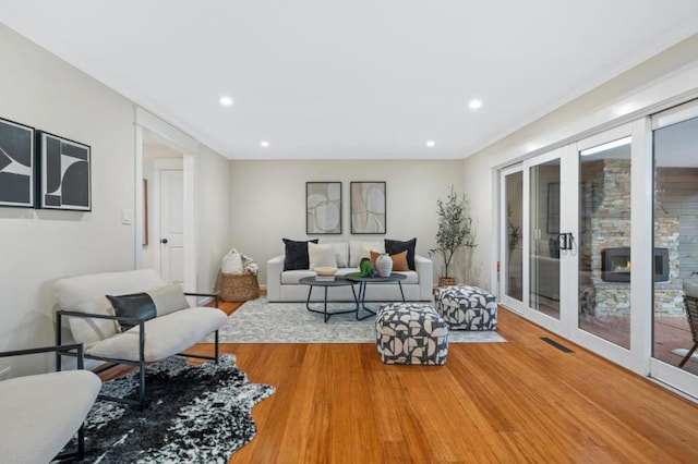 living room featuring wood-type flooring, french doors, and a healthy amount of sunlight