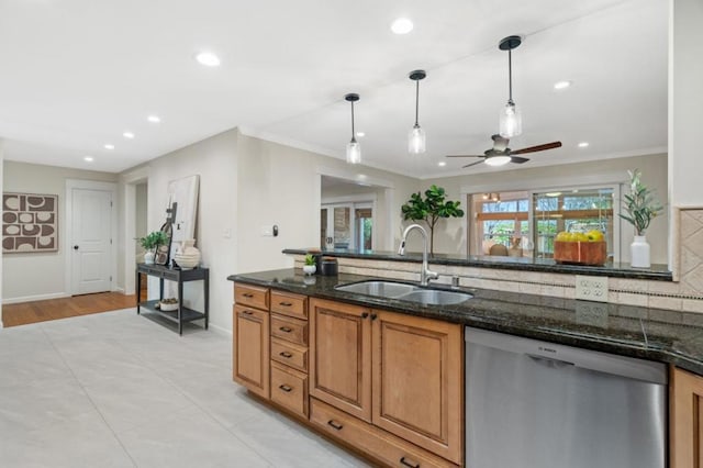 kitchen featuring dark stone countertops, sink, pendant lighting, and stainless steel dishwasher